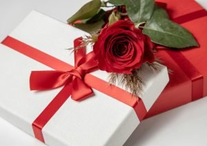 Close-up of beautifully wrapped gift boxes with a red rose, perfect for romantic occasions.